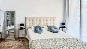 A bedroom with a large bed, two bedside tables, a mirror, and a view of the outdoors. - Gorgeous home in Noves (Noves)