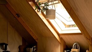 Une cuisine moderne avec un îlot central en bois, des tabourets de bar et une verrière.