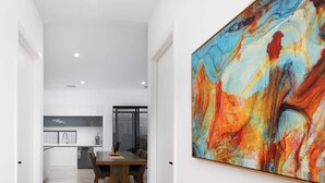 A modern interior with a dining area, a kitchen, and a large abstract painting on the wall. - Large Family entire house adelaide 4br2ba (Rostrevor)