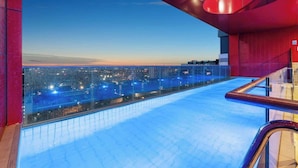 A rooftop infinity pool with a city view, glass railings, and a red architectural feature. - Comfort city view apartment Central Adelaide (Adelaide)