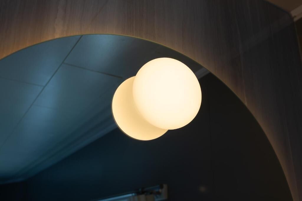 Un interior moderno con un diseño de techo singular que presenta una gran lámpara esférica iluminada.