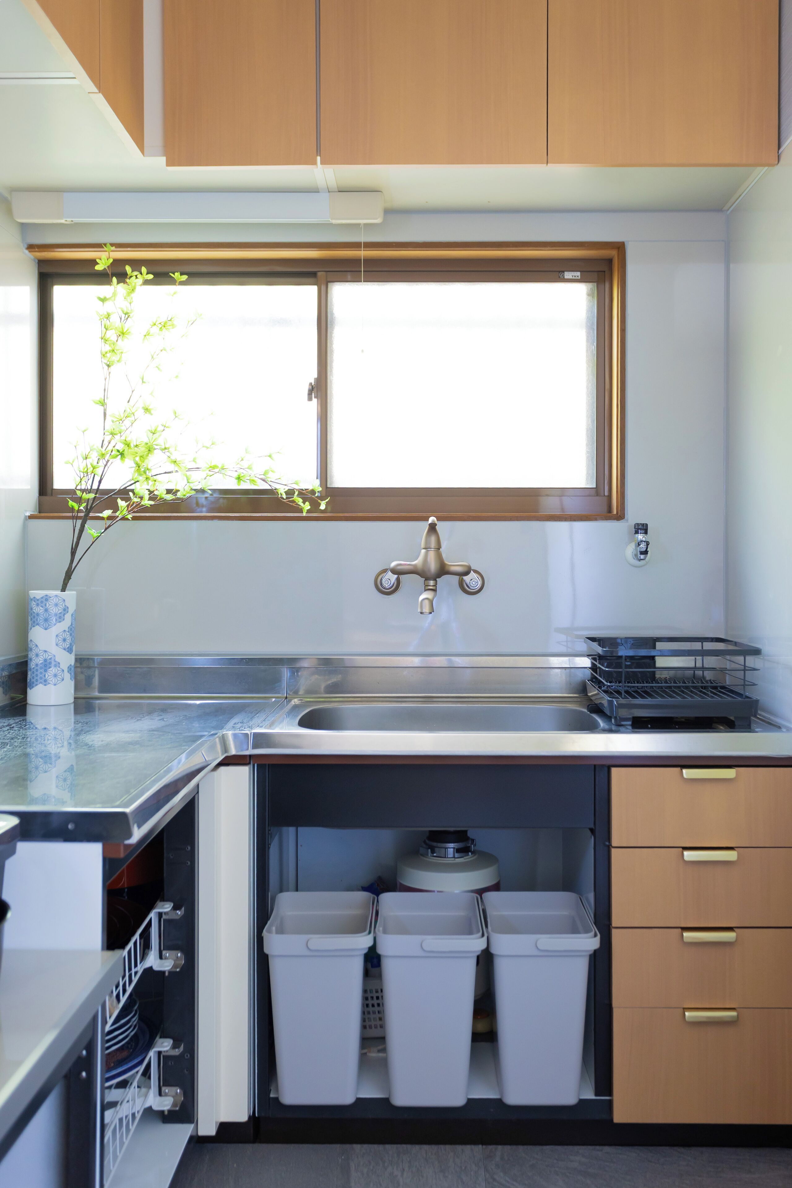 Cocina compacta con ventana sobre el fregadero, lavavajillas integrado y armarios de almacenamiento.
