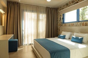 Ein Schlafzimmer mit einem Bett, einem Schreibtisch und einem fensterbepflanzten Fenster.