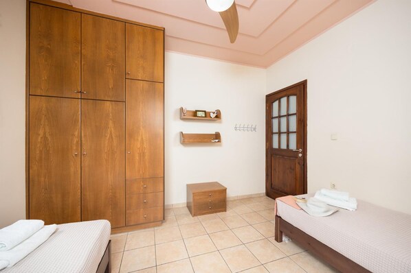A bedroom with a bed, a wardrobe, a small chest of drawers, and a door with a frosted glass panel. - Aloni Villa in Apokoronos (Apokoronas)
