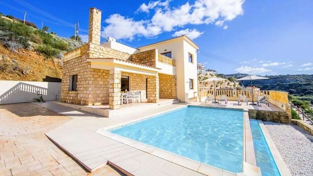 A two-story house with a swimming pool, stone exterior, and a view of the hills. - Villa Aqua View in Kissonerga (Pegeia)