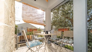 A balcony with a table and chairs, a view of the surrounding area, and a building in the background. - Villa Bella Vista in Sveti Filip i Jakov (Sveti Filip i Jakov)