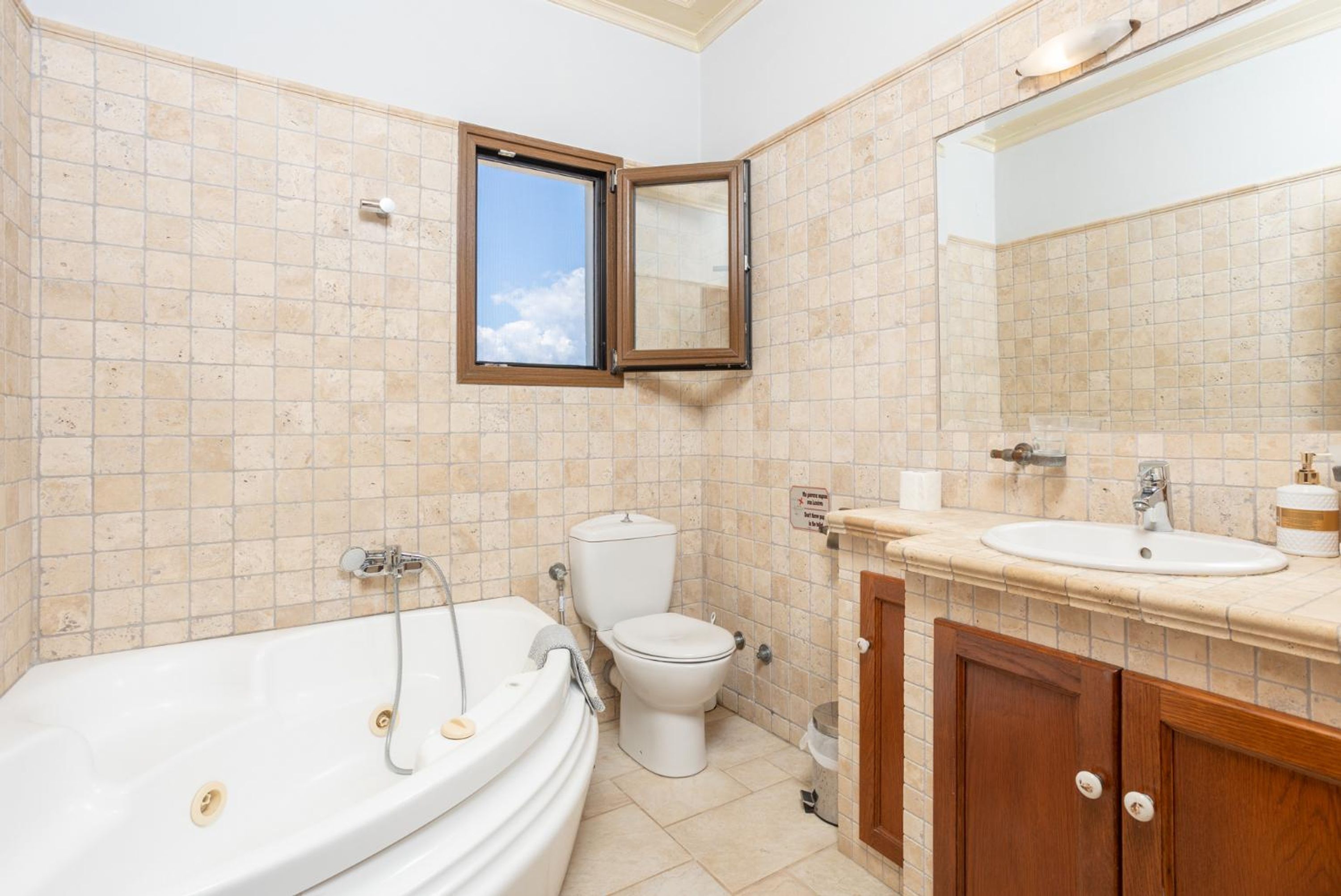 Ein Badezimmer mit Badewanne, Toilette, Waschbecken und Spiegel.