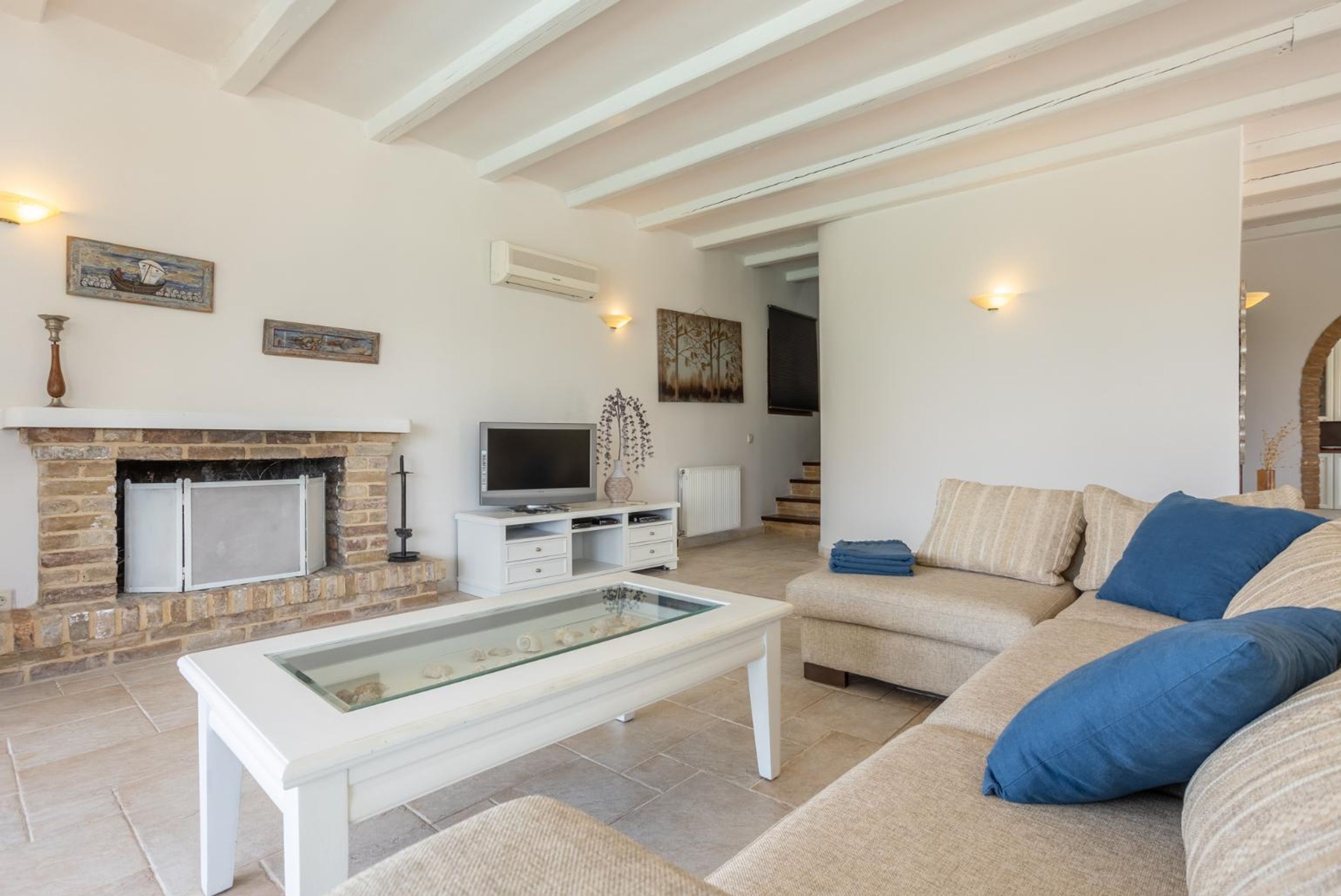 A living room with a fireplace, a television, and a sofa.