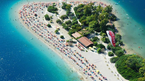 An aerial view of a beach with rows of umbrellas and beachgoers. - Villa Tara in Oludeniz (Fethiye)