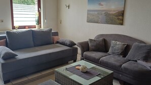 A living room with two sofas, a coffee table, and a painting on the wall. - Cozy vacation apartment quiet in Lindlar-Linde, approx. 30 km from Cologne (Lindlar)