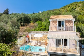 A two-story building with a pool, outdoor seating, and a balcony. - Villa Magda Dione in Gaios (Paxos)