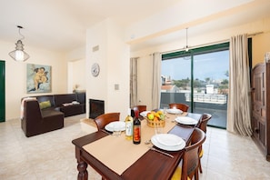 A dining area with a table set for four, a sofa, and a painting on the wall. - Villa Phedra in Kefalas (Apokoronas)