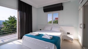 Een moderne slaapkamer met een groot bed, een raam met uitzicht en een balkon.