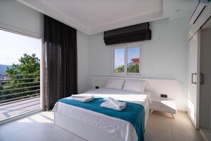 Ein modernes Schlafzimmer mit einem großen Bett, einem Fenster mit Aussicht und einem Balkon.