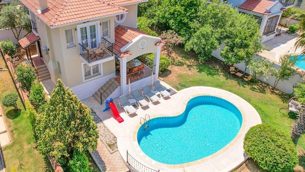 A two-story house with a swimming pool, a slide, and a patio with lounge chairs. - Villa Rosetta in Oludeniz (Fethiye)