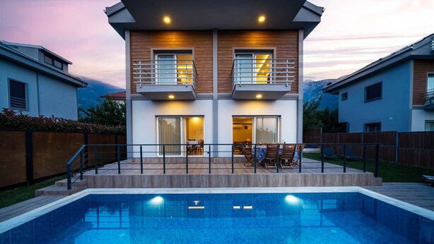A modern two-story house with a swimming pool, wooden deck, and outdoor seating area. - Villa Riva in Oludeniz (Fethiye)