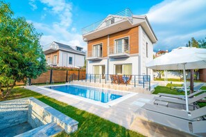 A modern two-story house with a swimming pool, outdoor furniture, and a well-maintained garden. - Villa Riva in Oludeniz (Fethiye)
