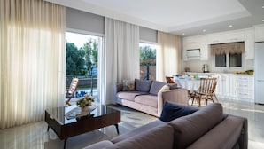 A modern living room with a sofa, coffee table, and a dining area with chairs. - Villa Riva in Oludeniz (Fethiye)