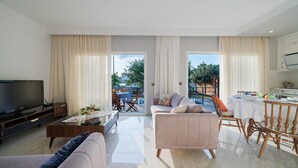 A modern living room with a sofa, TV, and dining area. - Villa Riva in Oludeniz (Fethiye)