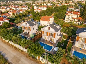 A residential area with multiple houses, a swimming pool, and a well-maintained garden. - Villa Riva in Oludeniz (Fethiye)