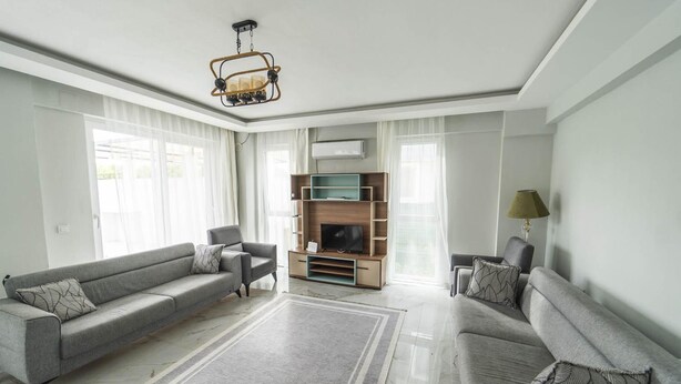 A modern living room with two grey sofas, a TV stand, and a lamp. - Villa Maya in Ortaca (Ortaca)