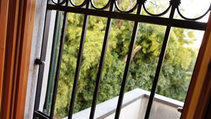 Ein Balkon mit Metallgeländer und Blick auf Grünflächen.