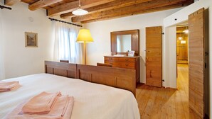 Ein Schlafzimmer mit einem Bett, einem Holzschrank und einem Spiegel.