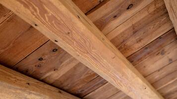 A wooden ceiling with exposed beams and a central beam structure.