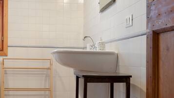 Ein Badezimmer mit Waschbecken, Handtuchhalter aus Holz und einem Holzschrank.