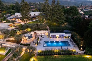 Um empreendimento luxuoso com uma grande piscina, área de estar externa e um jardim bem cuidado.