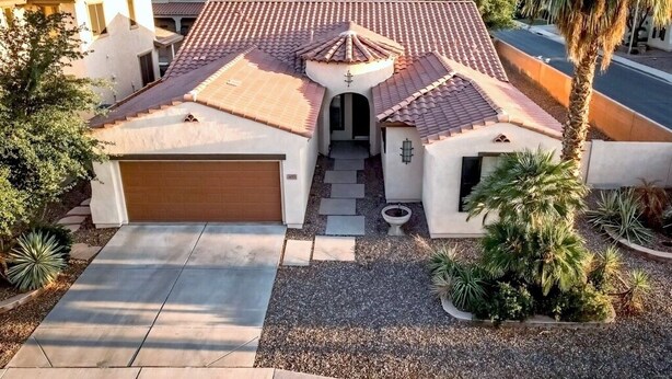 Ein Wohnhaus mit Ziegeldach, einer Garage und einer Auffahrt zur Einfahrt.