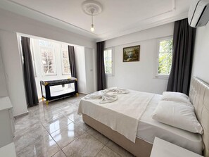 A bedroom with a bed, a bench, and a painting. - Villa Fergana in Oludeniz (Fethiye)