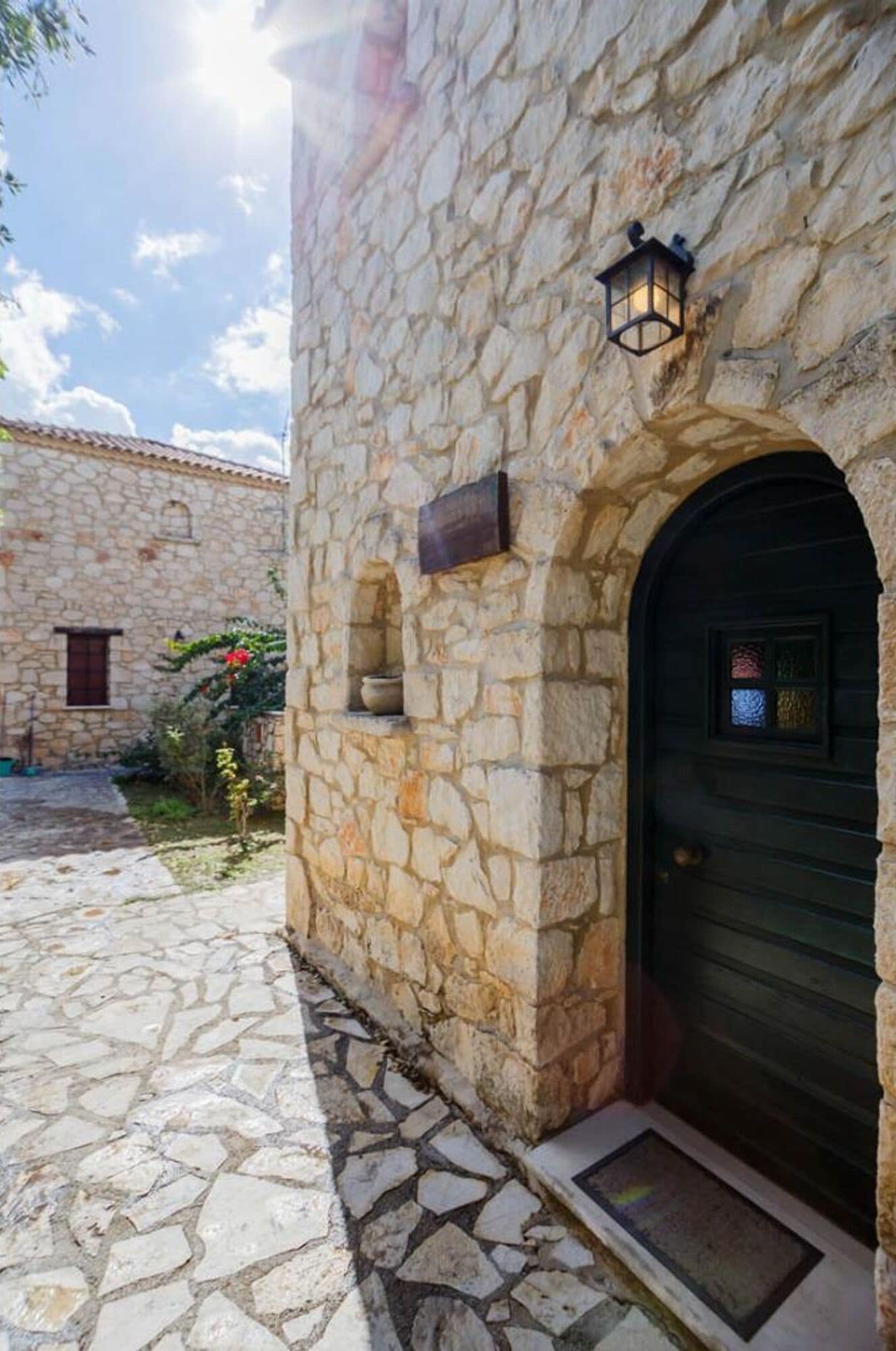 Un edificio de piedra con una puerta de madera oscura y una ventana pequeña.
