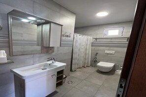 A modern bathroom with a sink, mirror, toilet, and shower area. - Elegant 4-Bedroom, 3-Bathroom Apartment in the Heart of Ilidža, Sarajevo (Ilidža)