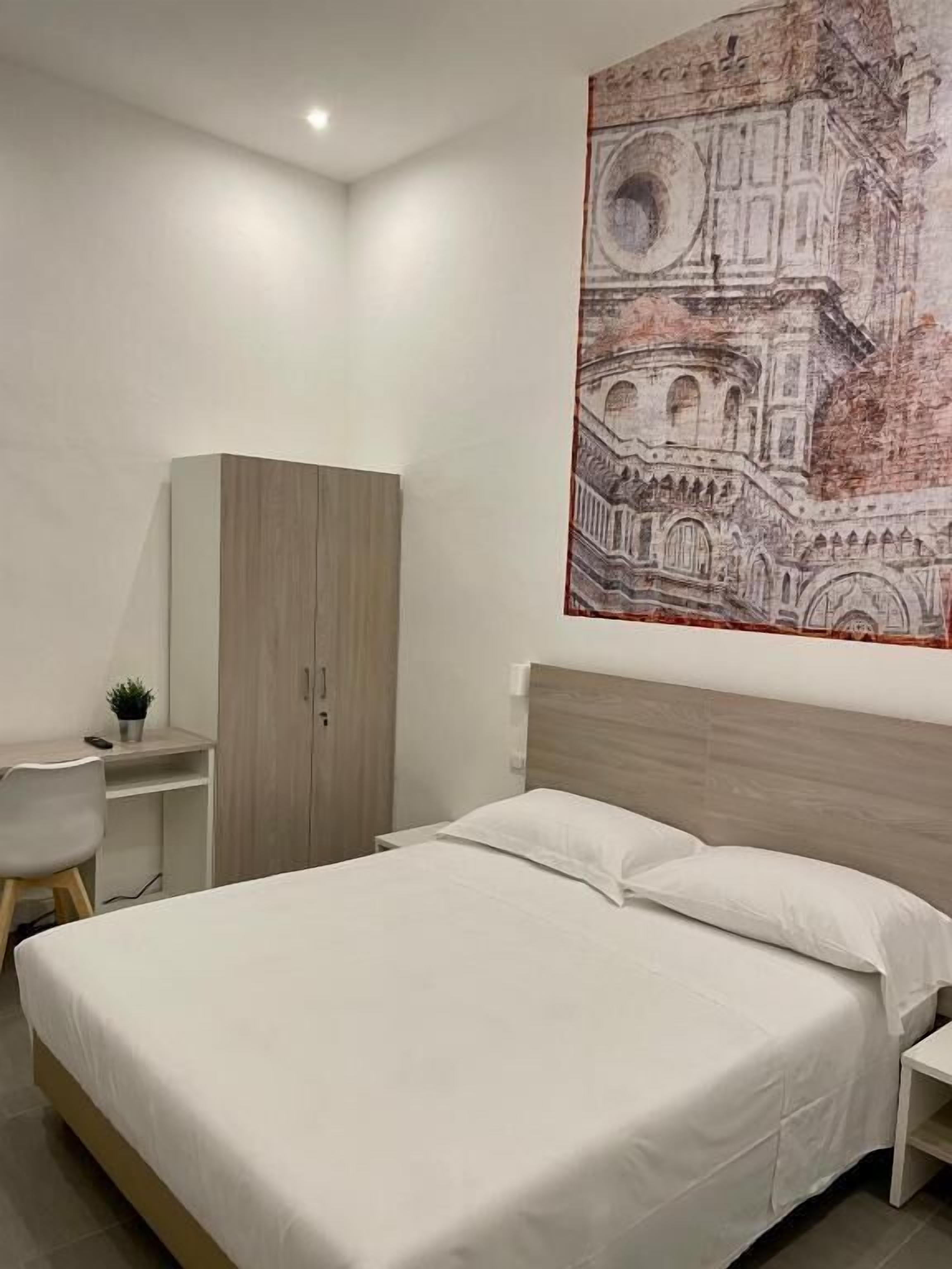 Un dormitorio moderno con una cama grande, un escritorio y un armario.