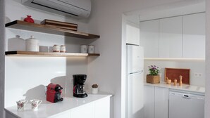 Eine moderne Küche mit weißen Schränken, einer Kaffeemaschine und einem Geschirrspüler.