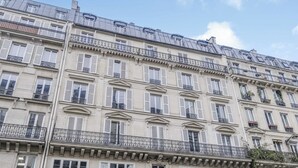 A multi-story building with balconies, large windows, and a classic architectural style.