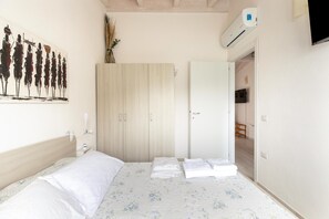 A bedroom with a bed, a wardrobe, and a painting on the wall. - Attic with terrace and swimming pool (Badesi)