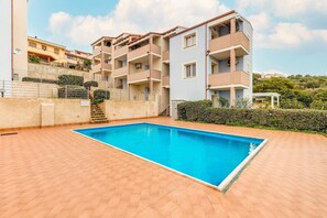 A residential building with a swimming pool, balconies, and a staircase leading to a lower level. - Attic with terrace and swimming pool (Badesi)