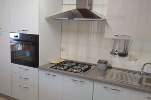 Frigorífic, forn, placa de cuina i una taula de menjador 