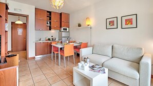 A compact living space with a kitchenette, dining area, and a sofa. - Appartement mit Seeblick auf den Luganersee (Porlezza)