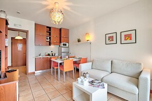 Ein kompakter Wohnbereich mit Küchenzeile, Essbereich und einer Couch.