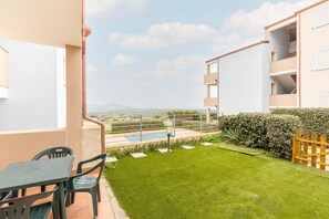 Un balcón con mesa y sillas, una piscina pequeña y vistas del paisaje.