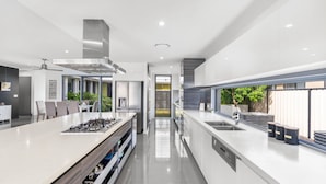 A modern kitchen with a central island, stainless steel appliances, and a view to the outdoors. - Tranquillit, TOP NOTCH (BANKSIA BEACH)