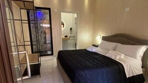 Un dormitorio moderno con cama, escritorio y espejo.