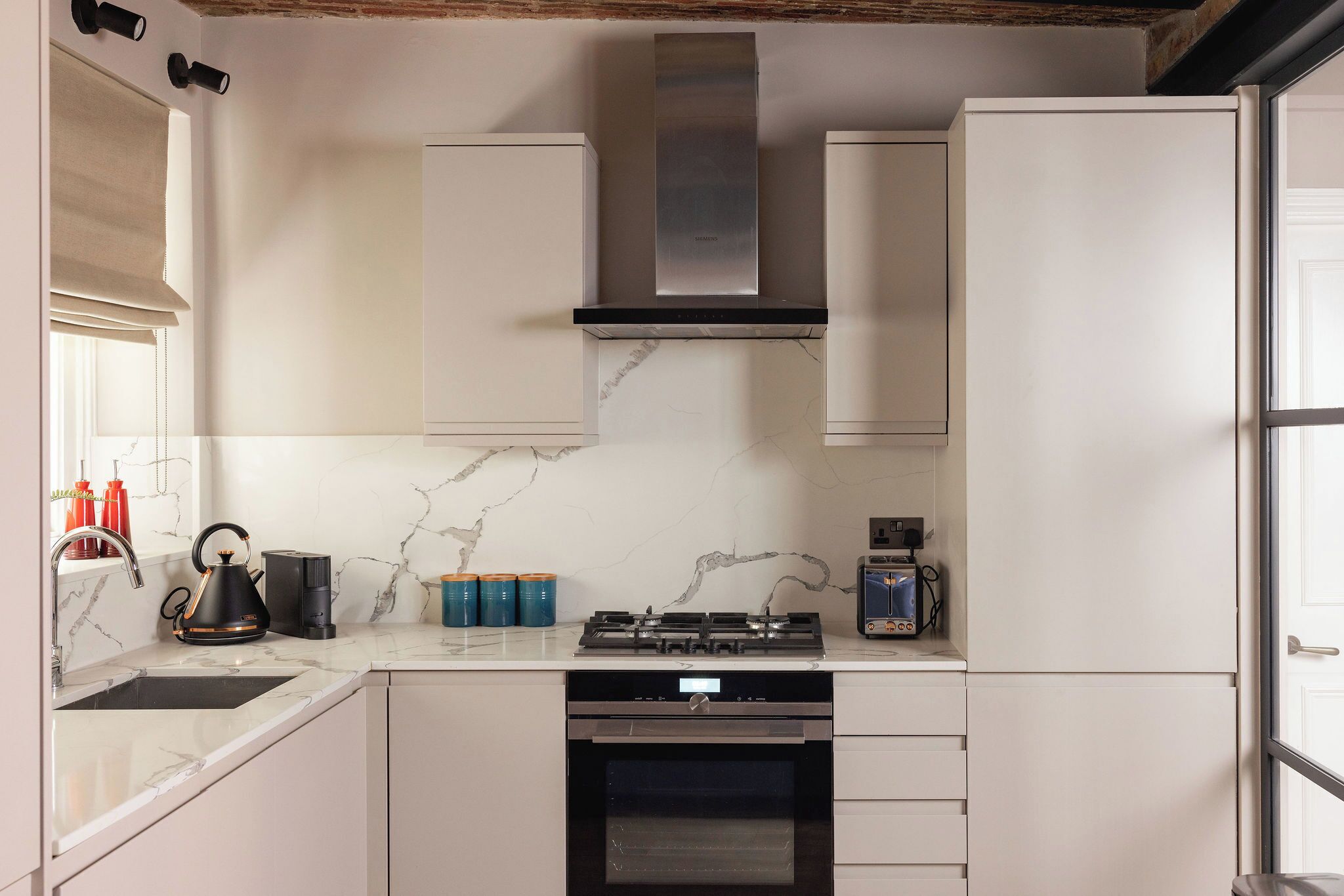 Eine moderne Küche mit Gasherd, Backofen und eingebauten Schränken.