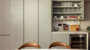 A compact kitchen with built-in cabinets, a wine rack, and a small refrigerator. - FiveM High Street Kensington (London)