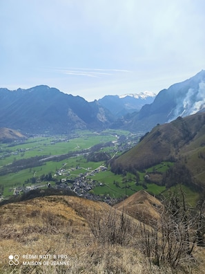 A valley with a small town, green fields, and mountains in the background. - Charming country house in the heart of the village (Osse-en-Aspe)
