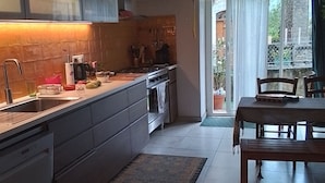 Una cucina moderna con isola centrale, forno integrato ed elettrodomestici in acciaio inossidabile.