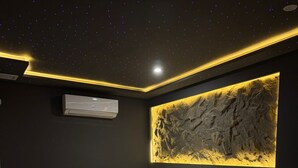 Een moderne slaapkamer met een bed, nachtkastje en een bijzondere kunstwerk aan de muur.